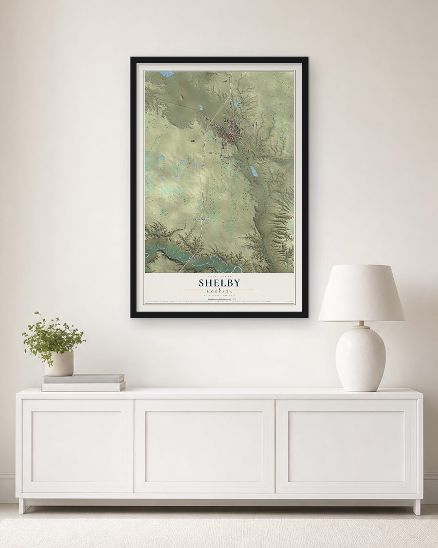 The Shelby, Montana map, 24 x 36 in, in a black wood frame on a living room wall