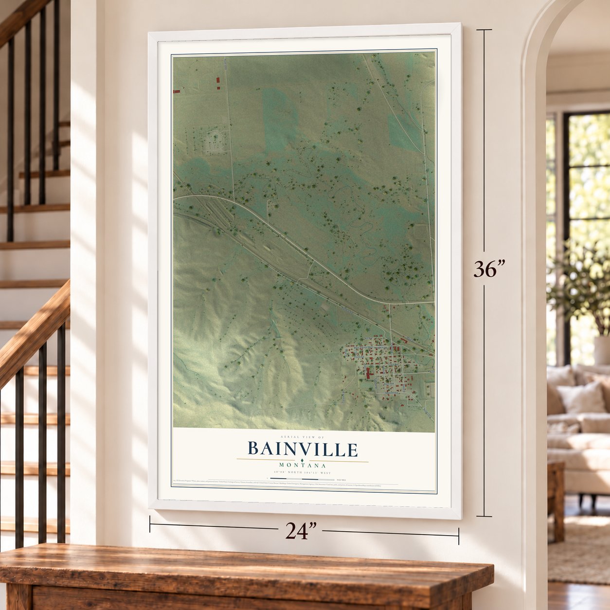 Bainville, Montana map, 24 x 36 inch print in a white frame by a staircase