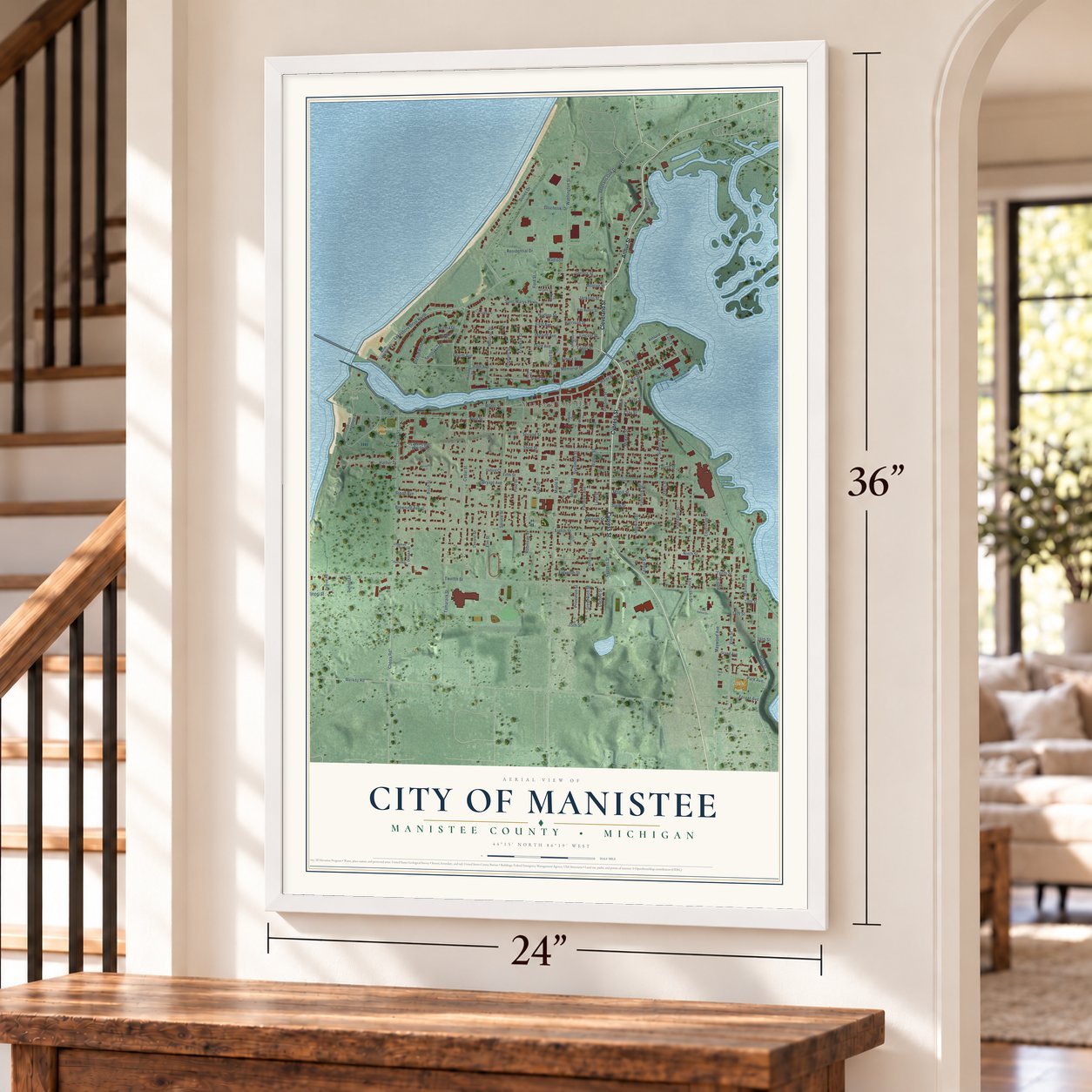 Manistee, Michigan map, 24 x 36 inch print in a white frame by a staircase