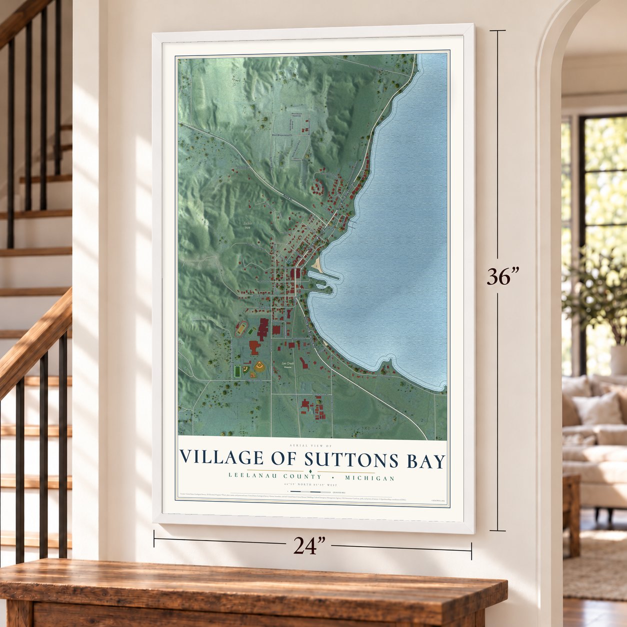 Suttons Bay, Michigan map, 24 x 36 inch print in a white frame by a staircase