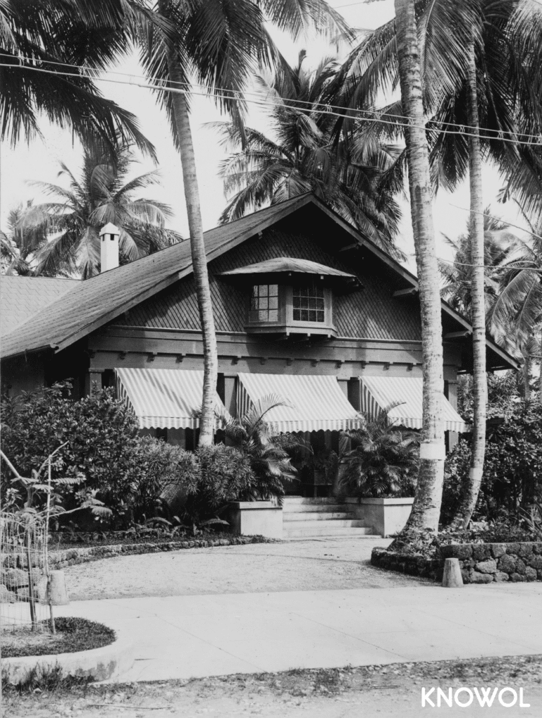 This picture shows an upper class Puerto Rican home with awnings on the front porch and palm trees adorning the yard.