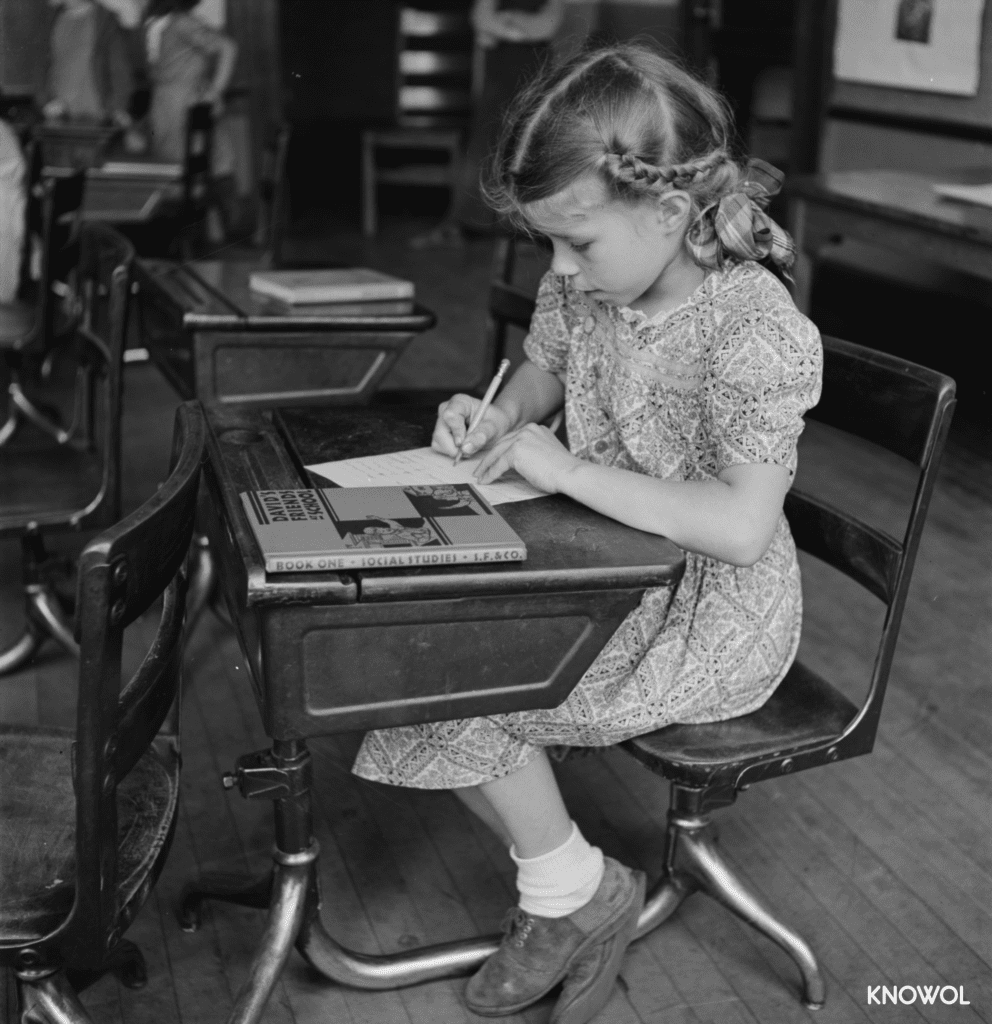 A young girl at Southington schoolhouse working out of a book titled "David's Friends at School", a book from 1936.