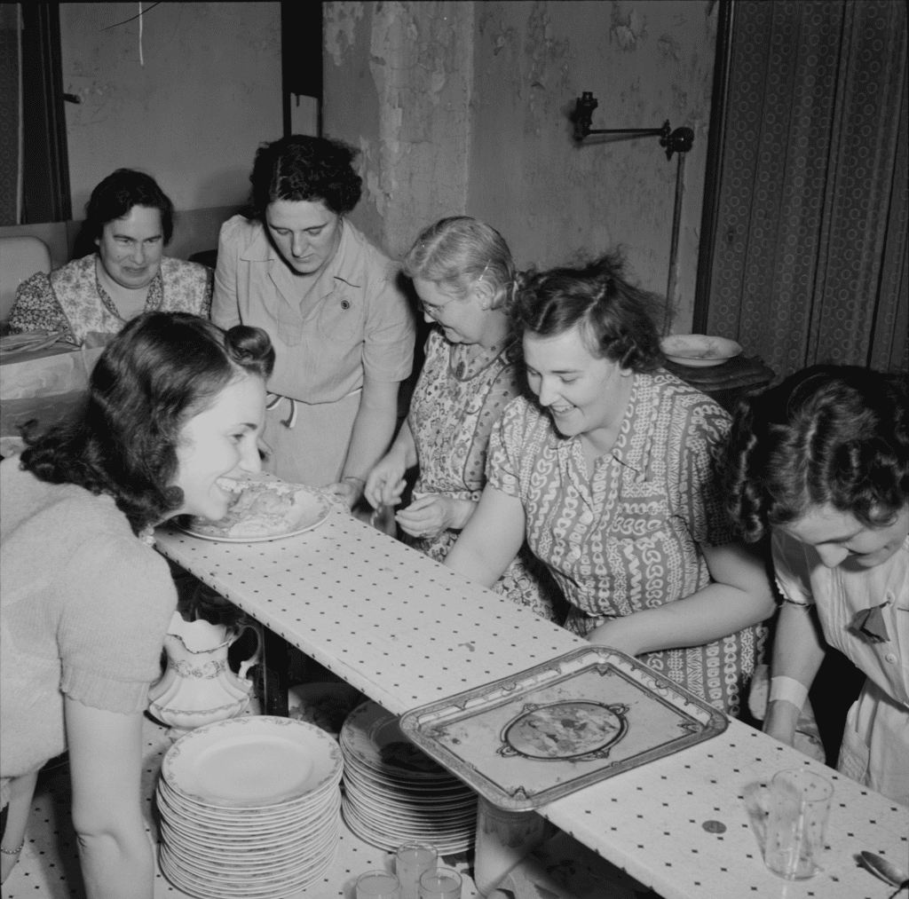 Women pitching in to clean the dishes after a meal.