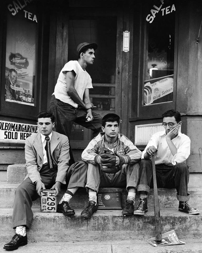 Seniors from Ansonia High School's class of 1949 pose for a photograph in front of a convenience store.