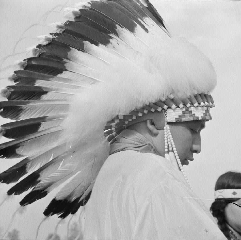 A young Indian wearing a headdress.