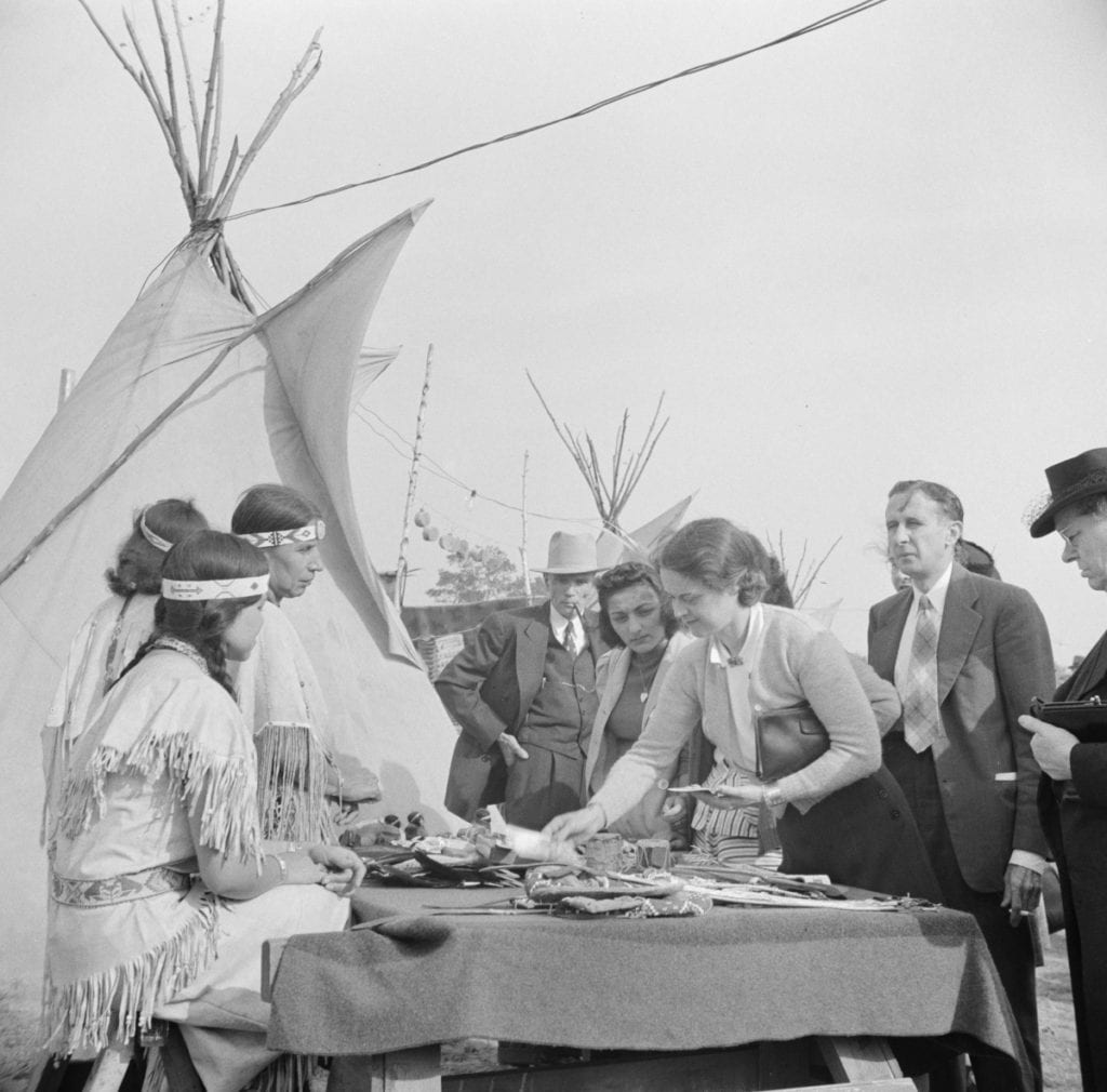 A woman looks over the charms, beadwork, ashtrays, and commercial Indian curios for sale at the locally sponsored Indian
