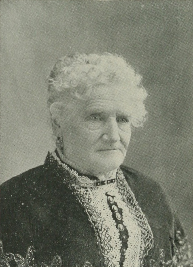 Portrait of Esther Morris as an older woman with white curly hair, in a dark dress with a lace front