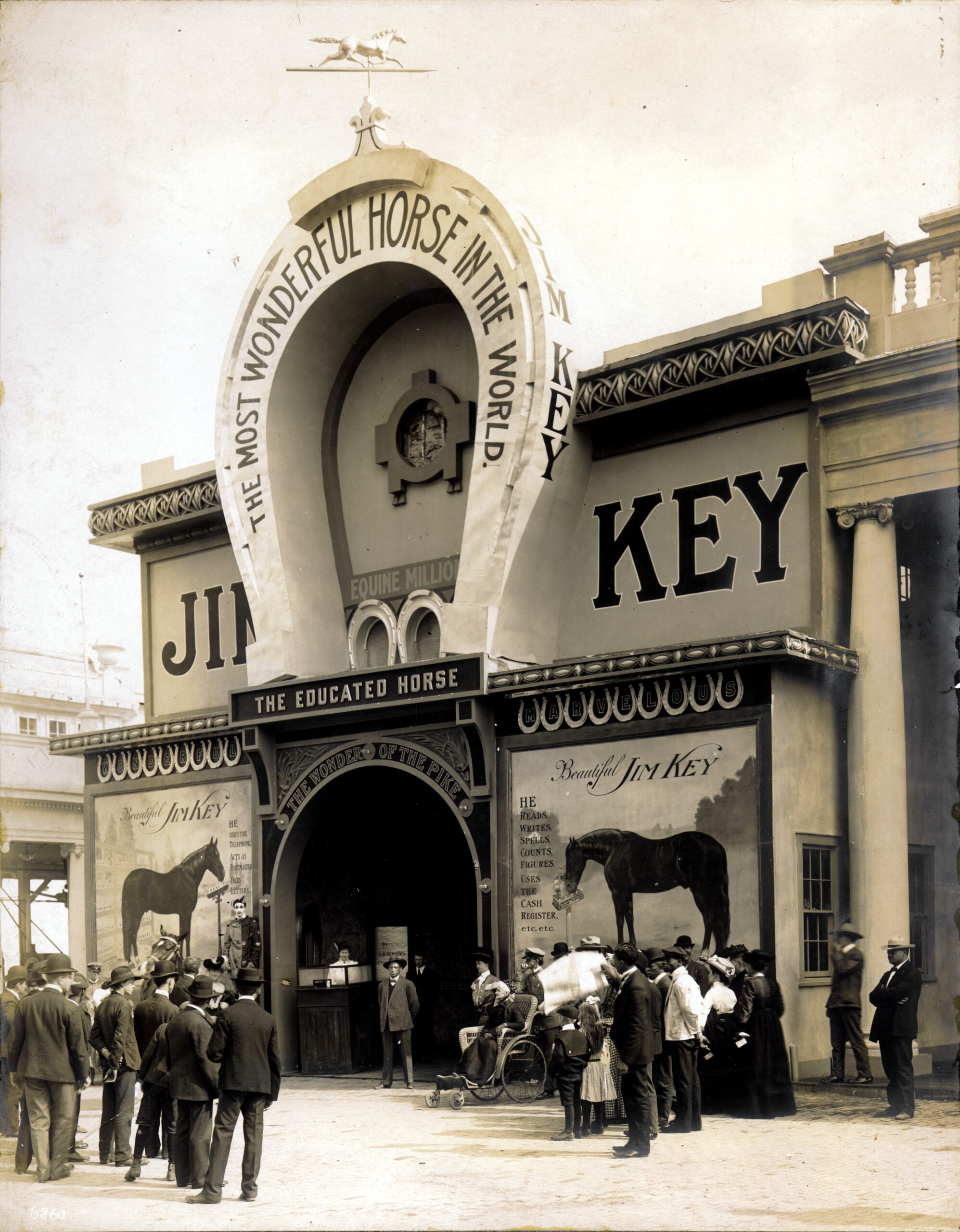 The Jim Key building on the Pike at the 1904 World's Fair, with a giant horseshoe over the entrance, posters of the horse and a crowd outside