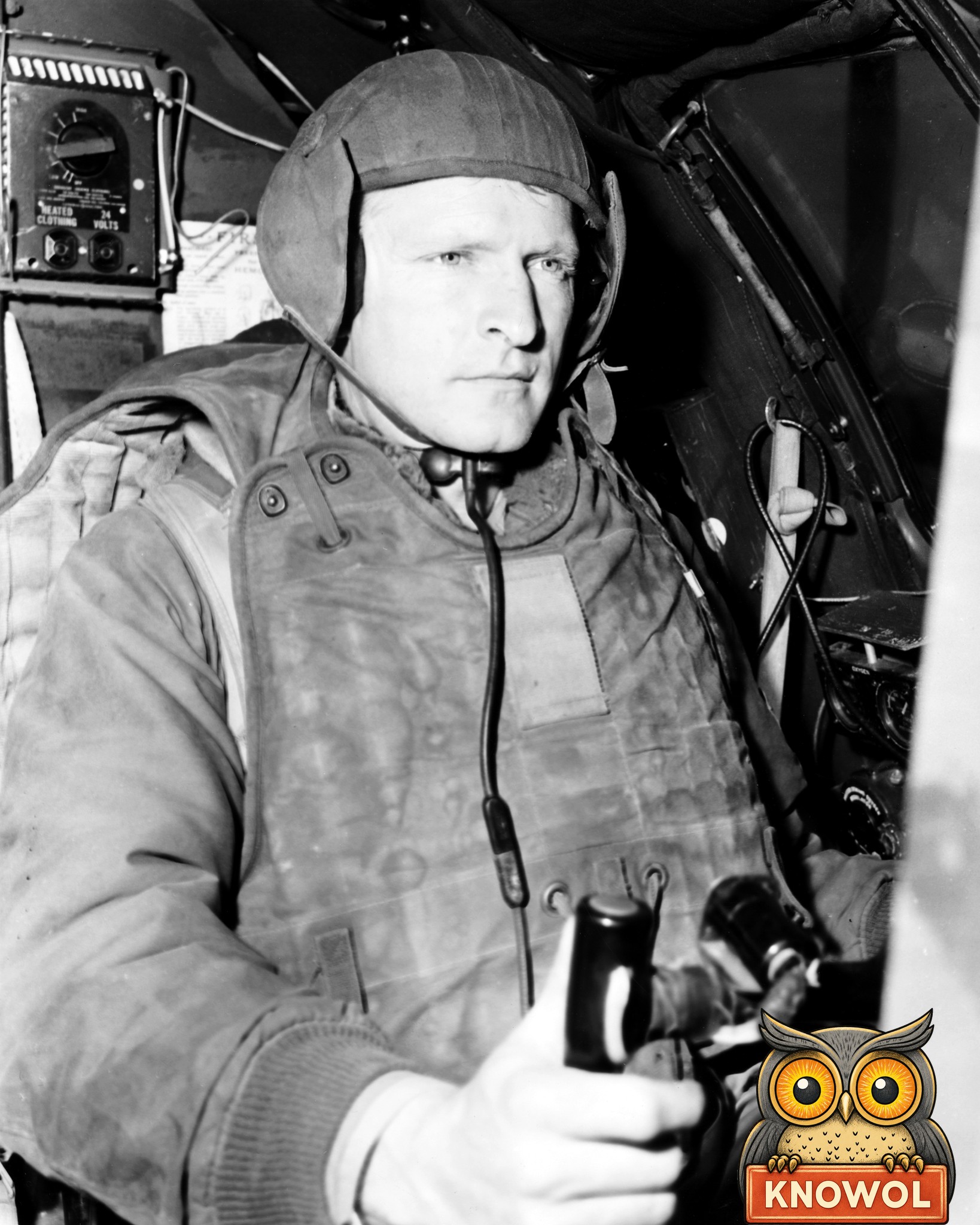 Captain Melvin E. Jarvis in a cloth flying helmet, throat microphone and heavy padded vest at the controls of his B-29 on Okinawa, May 1951